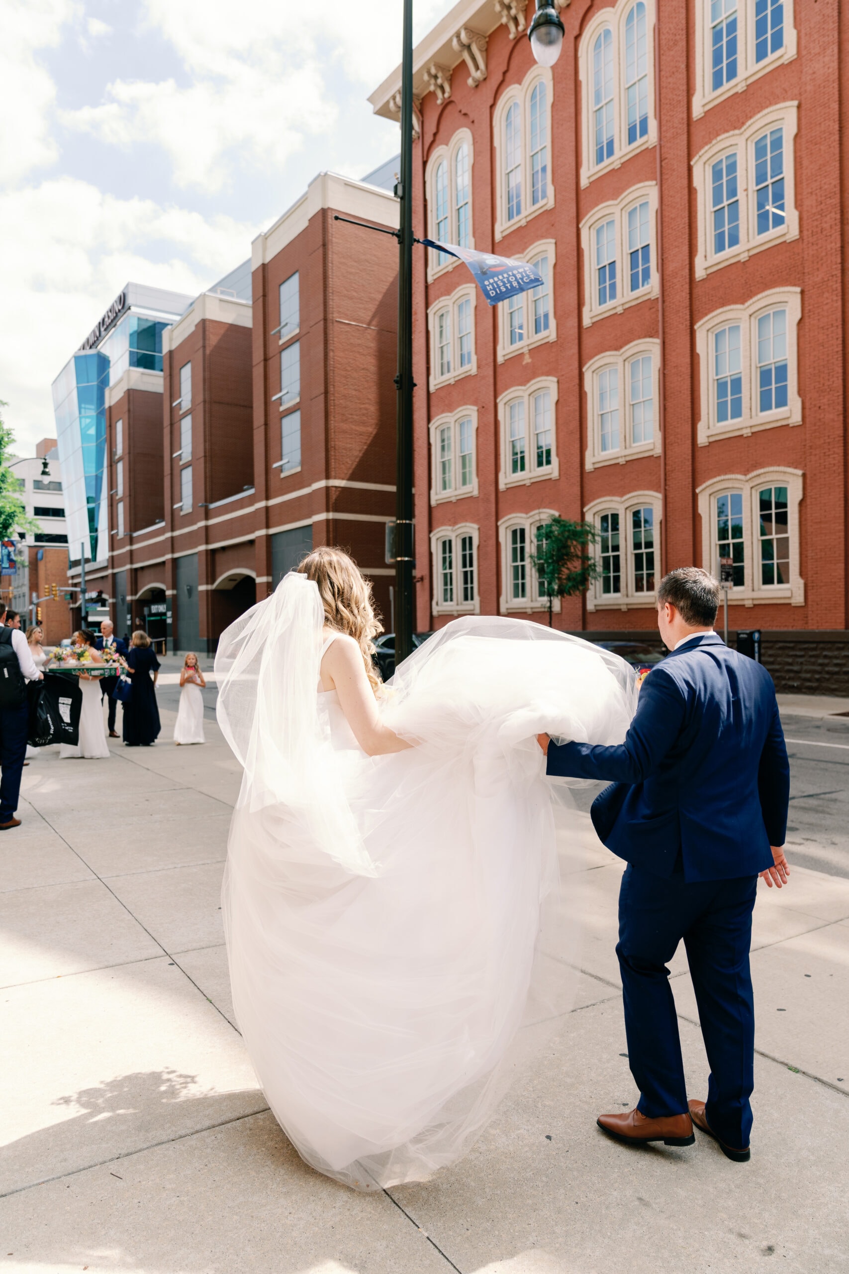 Couture Bride Ashley in Custom Sarah Kolis Gown and veil and groom in cathedral