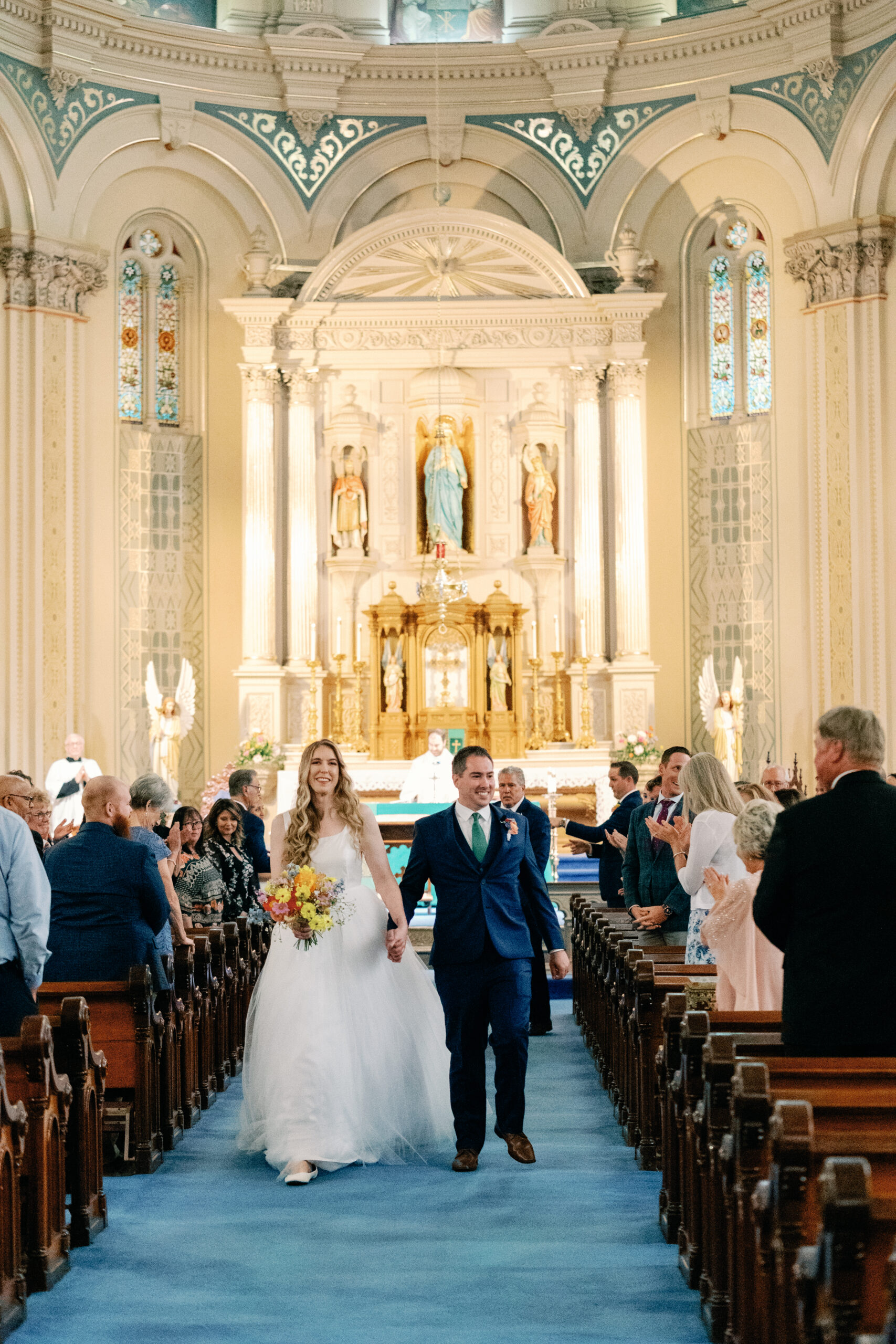 Couture Bride Ashley in Custom Sarah Kolis Gown and veil and groom in cathedral